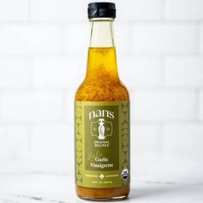 Bottle of nan's Organic Garlic Vinaigrette on a marble surface with a white background