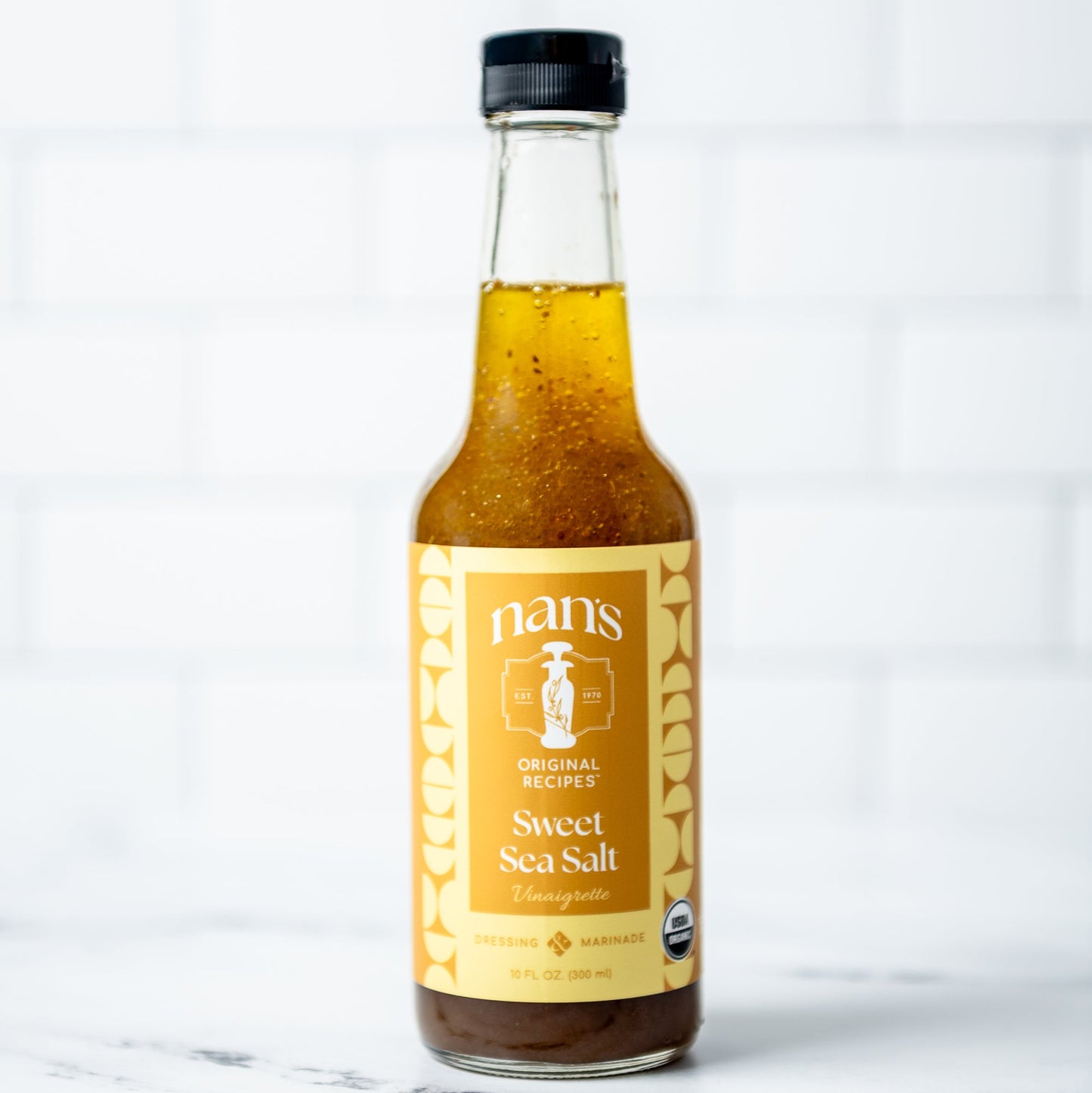 Bottle of Nan's Sweet Sea Salt on a marble surface with a white background